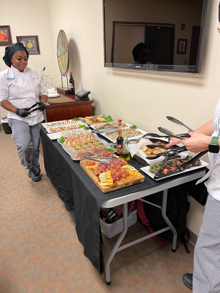 Culinary students preparing buffet display for event.