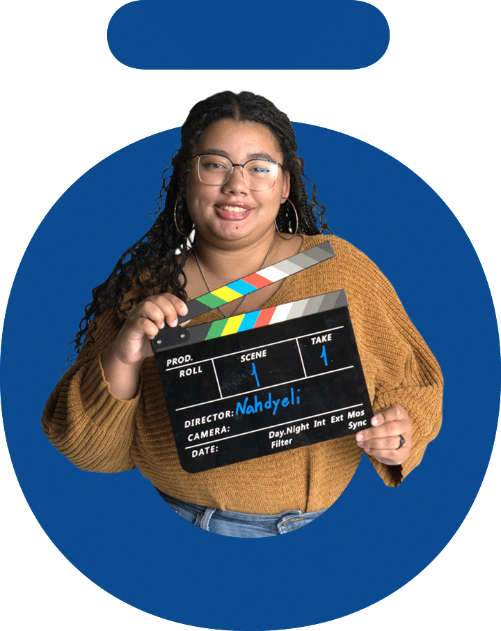 Nossi College student using a clapperboard during a film production project in the Video &amp; Content Creation Degree program.
